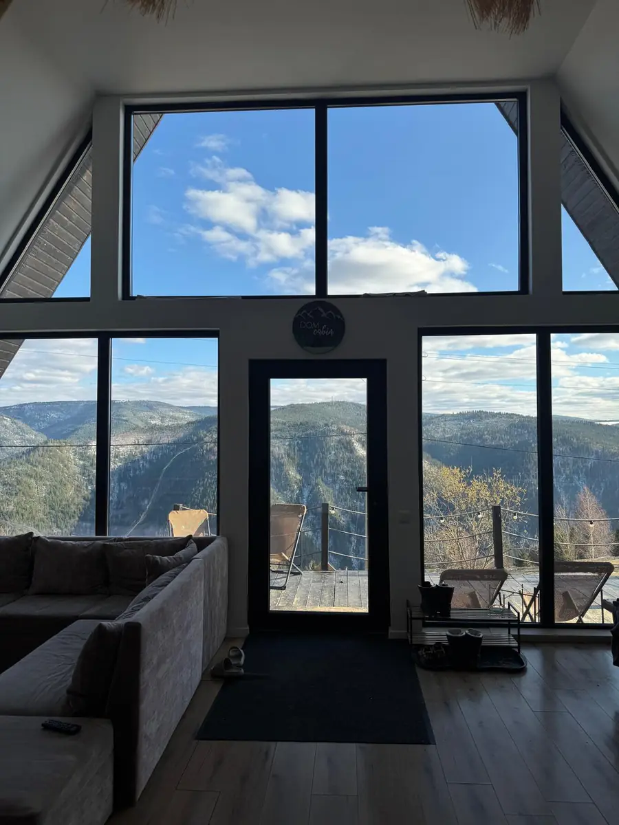 Living room with a wall of windows facing the mountains